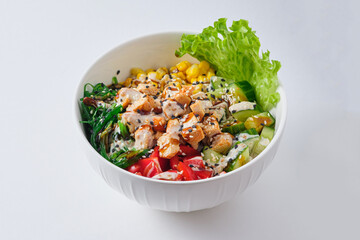 Poke Bowl with chicken, corn, pepper, rice and chukoy. Dish on a white plate.