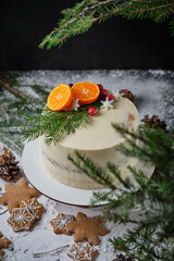 Delicious New Year's cake with poppy sponge cake and tangerine filling. A beautiful holiday cake for Christmas decorated with tangerines, fresh berries, snowflakes and spruce twigs.