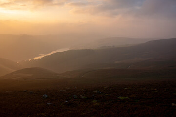 Naklejka na ściany i meble Ladybower water reserve hidden behind the magical evening fog at sunset in September, hiking trail in Peak District, England, UK