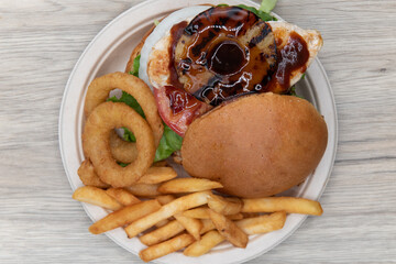 Overhead view of teriaki chicken sandwich glazed with sweet sauce and pineapple served with onion...