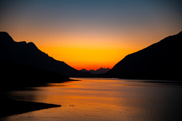 sunset over the lake between mountains