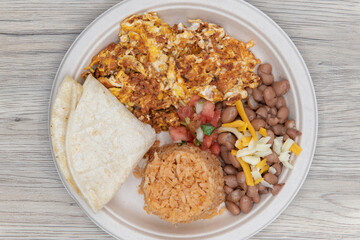 Overhead view of delicious Mexican cuisine of chorizo and eggs with a side of rice and beans for breakfast