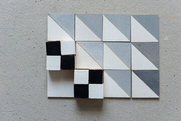 black and white hand painted wood craft cubes arranged on painted square & 3d tiles on a millboard...
