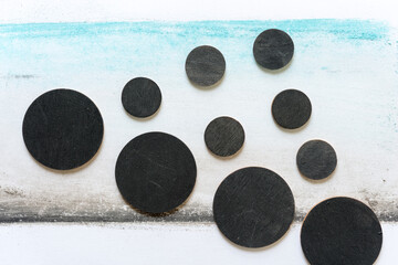 black trompe l'oeil spheres floating in a chalk pastel landscape