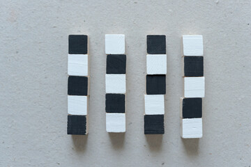 four columns of hand painted wood craft cubes arranged on a millboard background - photographed...