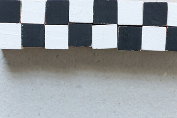 black and white hand painted wood craft cubes arranged on a millboard background - photographed...