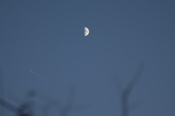 Day moon and a plane.