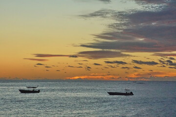 Sunset silhouetting boats in a bay in Fiji © Angela