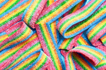 Tuinposter Colorful jelly candies in sugar sprinkles. Sour flavored rainbow candy background © Laima