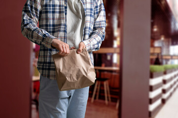 person holding and giving the disposable food delivery paper bag