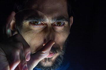 hombre con vidrio con aumento sobre su rostro 
