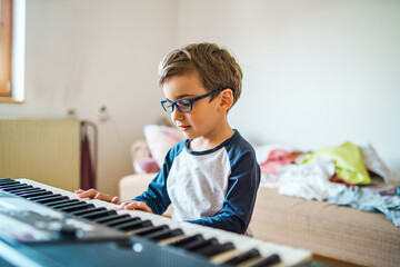 Small caucasian boy four years old learning to play piano at home © Miljan Živković