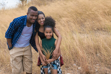 african american family travel together along trekking trail on mountain