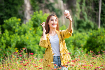 Fototapeta premium Tourist asian woman relax and freedom in beautiful blooming cosmos flower garden. Travel and Lifestyle Concept.