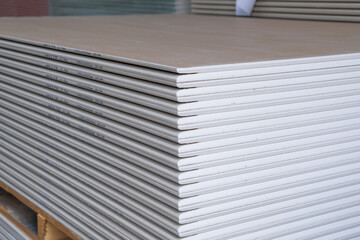 The stack of WHITE Standard Gypsum board panel. Plasterboard. Panel Type A designed for indoor walls, partitions and ceilings, construction site - obrazy, fototapety, plakaty