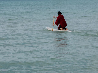 Fototapeta na wymiar Pirate in red cloth sailing with a boat in blue lake