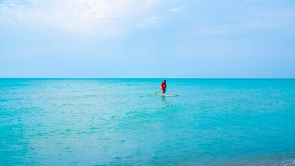 A pirate in red cloth sailing with a boat in the blue lake in Ontario, Canada.
