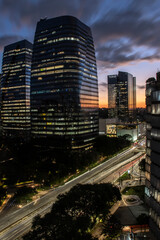 Fototapeta premium aerial view of commercial offices buildings on Juscelino Kubitschek Avenue, with the sunset in the background in the south side of Sao Paulo, city