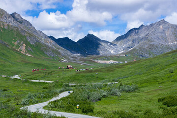 meadow under moutains that reach the clouds