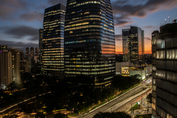 aerial view of commercial offices buildings on Juscelino Kubitschek Avenue, with the sunset in the background in the south side of Sao Paulo, city - obrazy, fototapety, plakaty