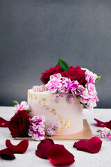 Beautiful Wedding cake with flowers on table and black background.