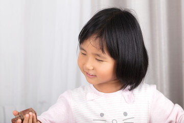 Oriental girl smiling looking at the seal in her hand