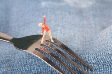 Miniature beautiful women do aerobics on the fork