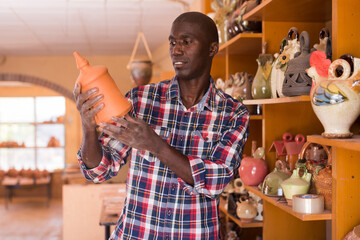 Afro-american shopper chooses handcrafted ceramic products. High quality photo