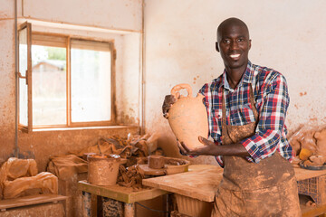 Friendly African man experienced pottery studio owner offering handmade ceramic goods