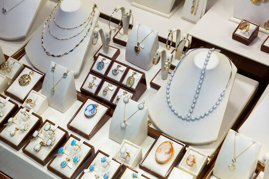 Collection Of Precious Metals Jewellery With Precious Stones Displayed For Sale On Shelves Of Jewelry Boutique