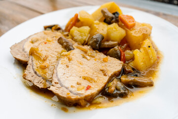 Homemade a Pork Loin with potatoes and mushrooms in sauce to the saucepan of long or slow cooking. Homemade food concept, healthy and natural food, slow cooking. Normal view.
