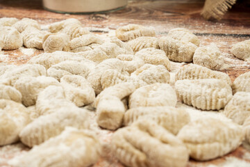 Close up of uncooked fresh gnocchi over wooden background
