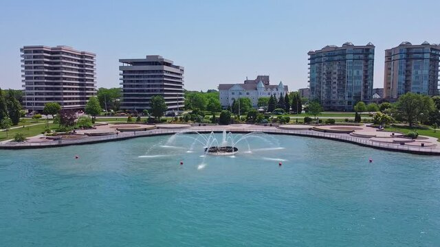 Drone video circling a fountain in the water beside a park