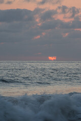 sun behind the clouds at sea