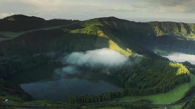 Drone flying over lake Azul and Verde in craters of dormant volcano, Miradouro do Cerrado das Freiras, Sao Miguel island, Azores, Portugal, Europe. Green mountains in morning light, 4k footage