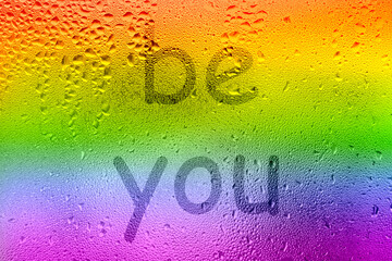The inscription on the sweaty glass. The word BE YOU written on glass with rainbow