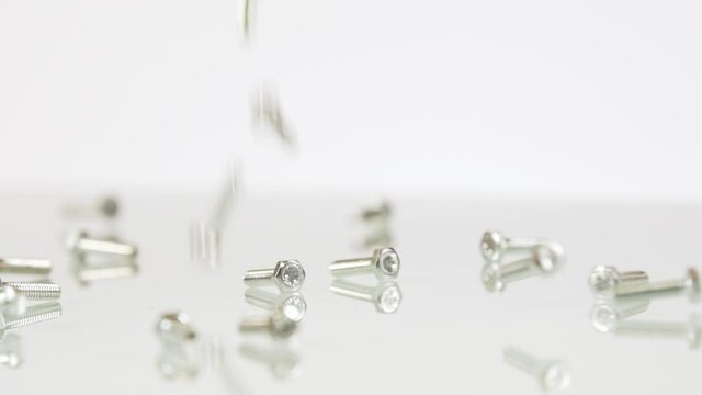 Small steel screw falling down on white background, isolated
