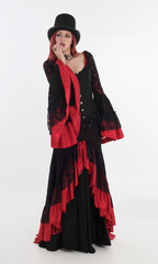 full length portrait of red haired woman wearing long black gothic vampire gown. standing pose on...
