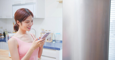 woman use phone with fridge