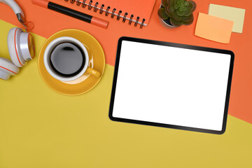 Top view digital tablet, coffee cup and sticky notes on colorful background.