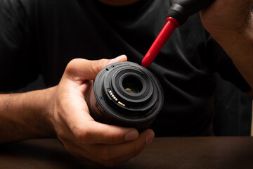 man cleaning his camera lens using a blower, camera dslr cleaning concept