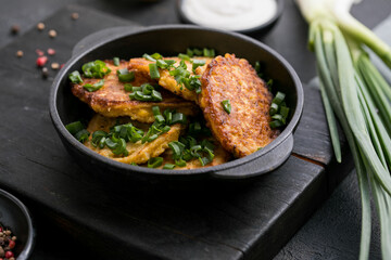 Delicious onion  fritters with sour cream and green onion on plate, closeup