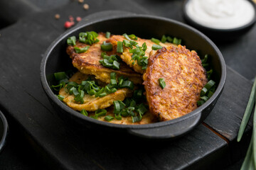 Delicious onion  fritters with sour cream and green onion on plate, closeup