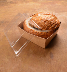 freshly bake big round bread bun with curry meat in bento box packaging for take away delivery on...