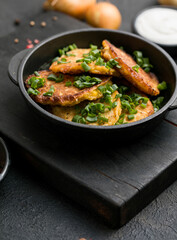 Delicious onion  fritters with sour cream and green onion on plate, closeup