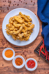 A plate of small crispy pork with Chengdu cuisine placed on a wooden table
