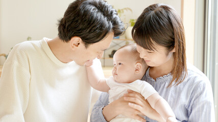 赤ちゃんを見つめるお父さんとお母さん