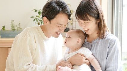 赤ちゃんを見つめるお父さんとお母さん