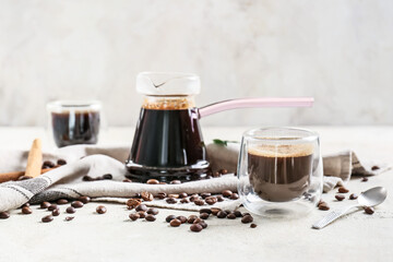 Pot and cup with delicious turkish coffee on light background