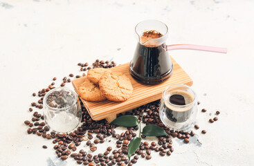 Pot and cup with delicious turkish coffee and cookies on light background